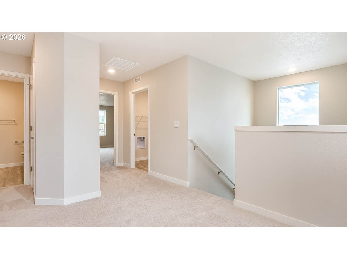 9194 Southeast Azalea Street Happy Valley, OR 97086 - Photo 15 of 32 a open living room with a hallway and stairs