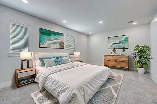 a bedroom with a bed a couch and potted plant