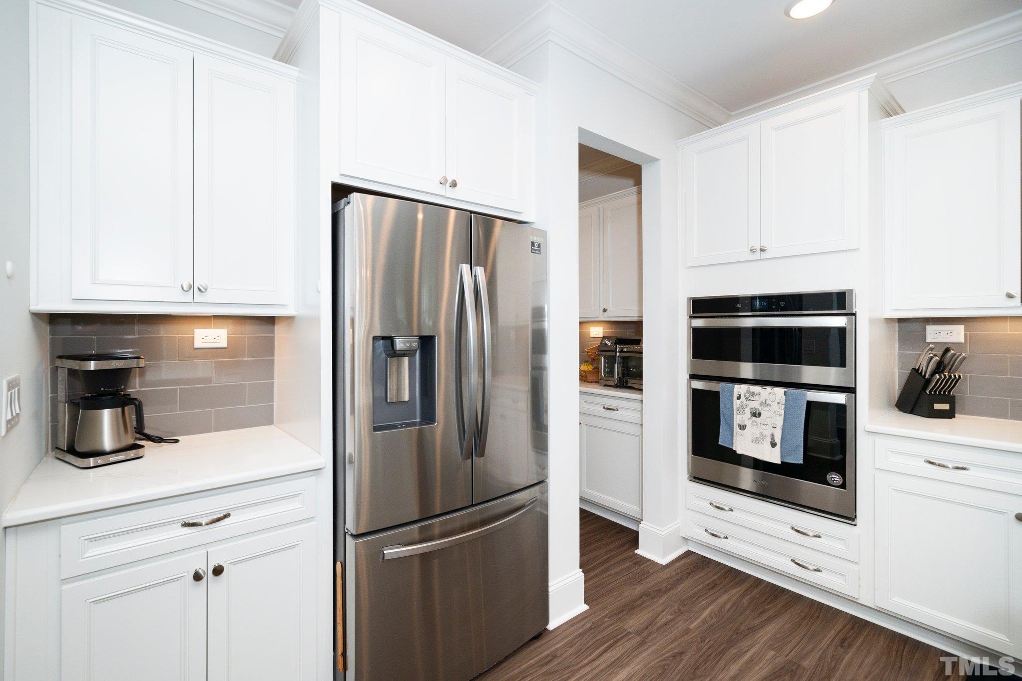 3271 Ripley River Road New Hill, NC 27562 - Photo 11 of 48 a kitchen with white cabinets and stainless steel appliances