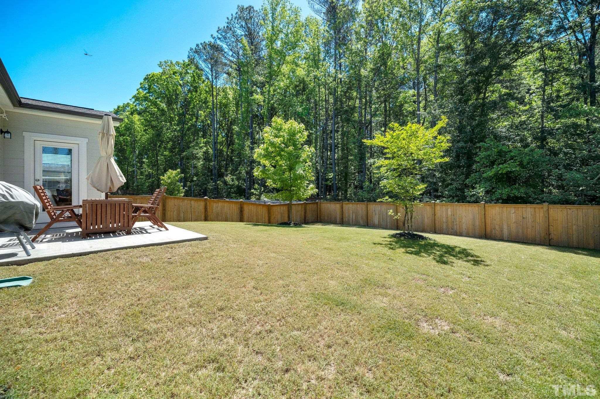 3271 Ripley River Road New Hill, NC 27562 - Photo 41 of 48 a view of a backyard with a large tree and wooden fence