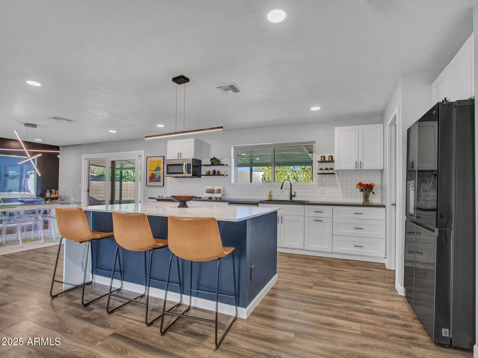 3010 East Yucca Street Phoenix, AZ 85028 - Photo 11 of 58 a kitchen with stainless steel appliances granite countertop a refrigerator a stove top oven and a dining table with wooden floor