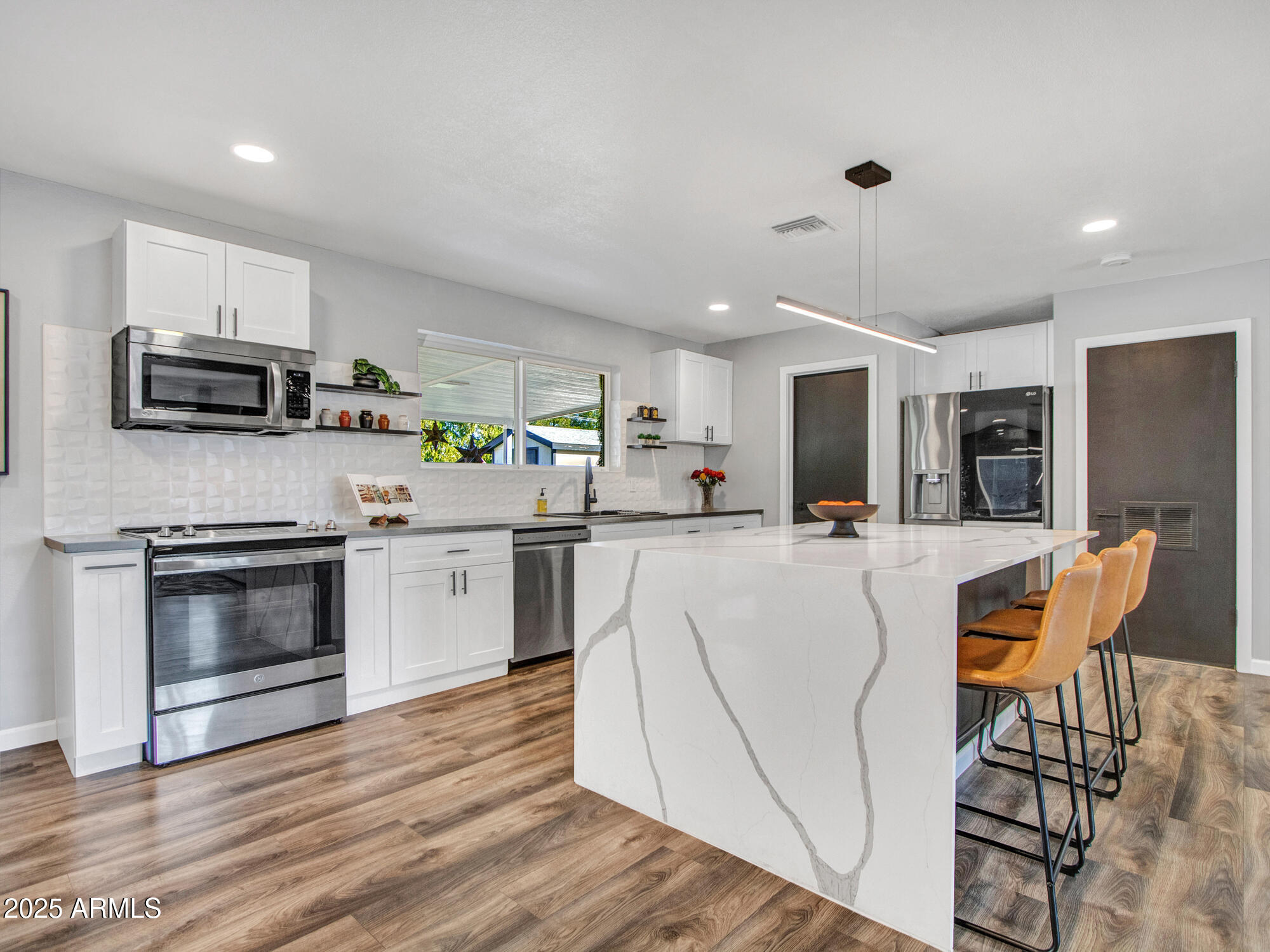 3010 East Yucca Street Phoenix, AZ 85028 - Photo 5 of 58 a kitchen with stainless steel appliances a stove a sink a microwave a refrigerator and cabinets