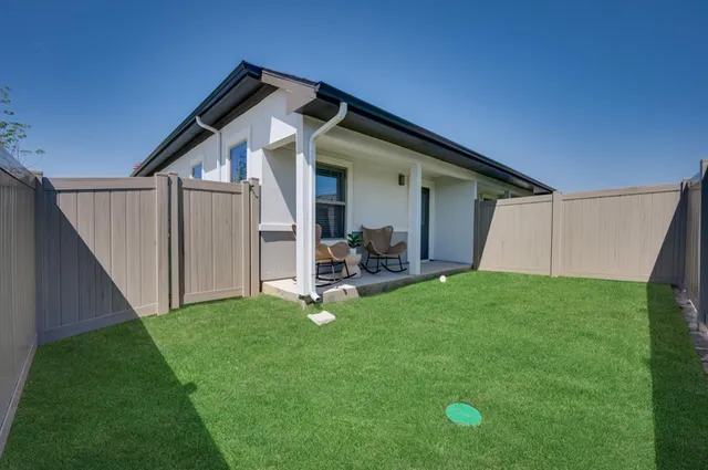 a view of a house with backyard and porch