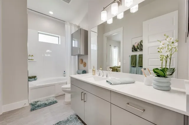 a bathroom with a sink a potted plant and a large mirror
