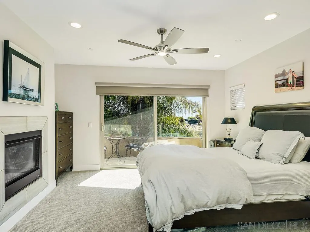 938 Opal Street San Diego, CA 92109 - Photo 24 of 70 a bedroom with a large bed and a fireplace