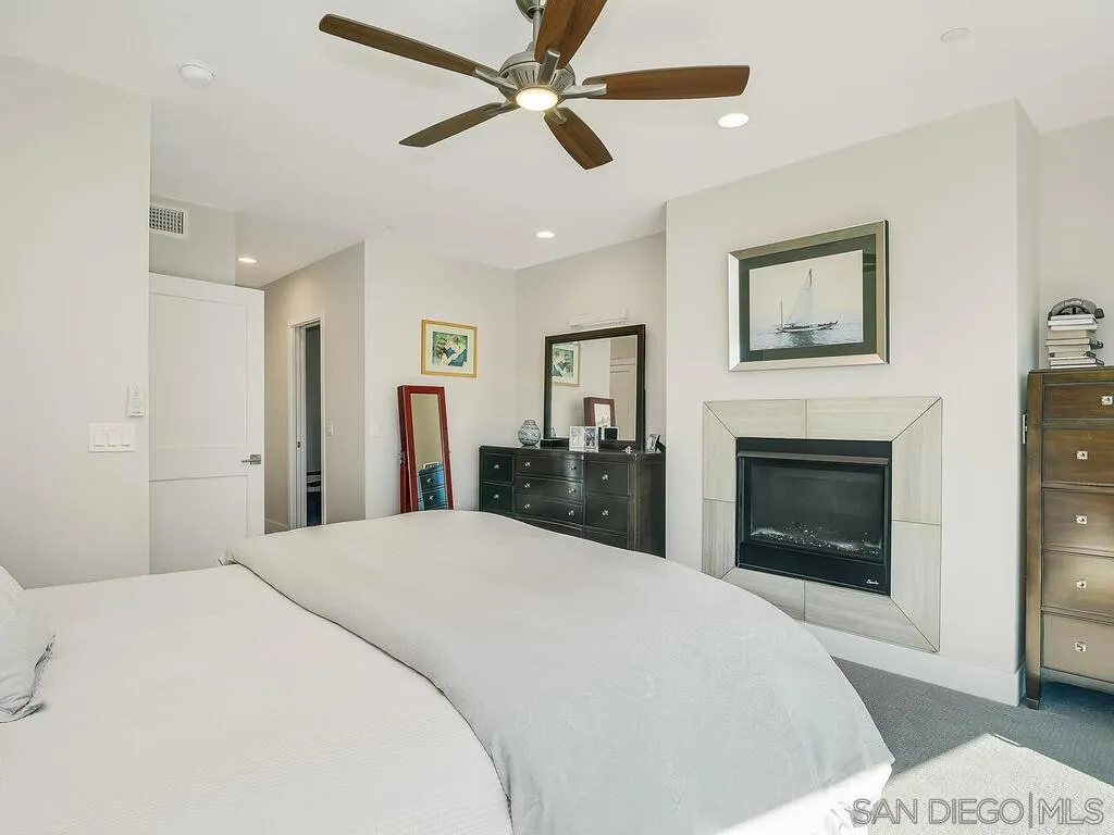 938 Opal Street San Diego, CA 92109 - Photo 25 of 70 a spacious bedroom with a large bed and a fireplace