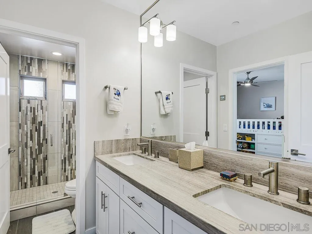 938 Opal Street San Diego, CA 92109 - Photo 33 of 70 a bathroom with double vanity sinks and a mirror