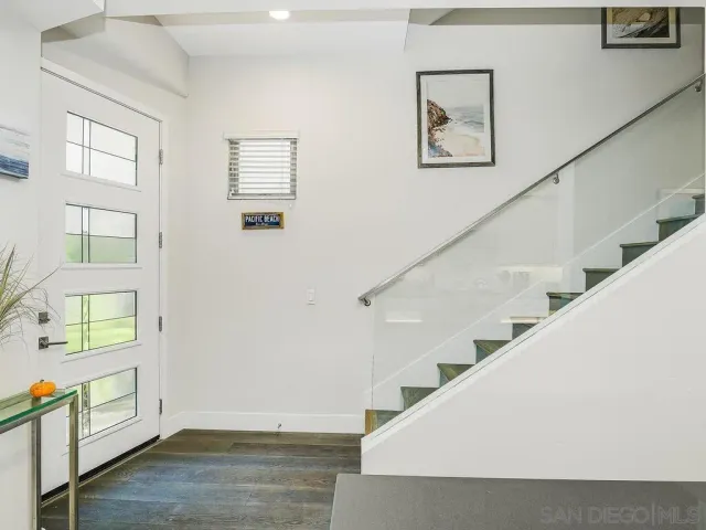 a kitchen with kitchen island a refrigerator a stove a sink and white cabinets with wooden floor