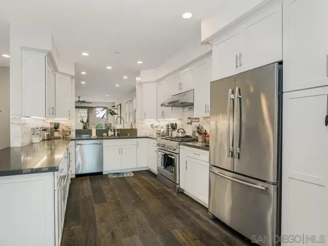 a kitchen with stainless steel appliances granite countertop a stove a sink and a granite counter tops