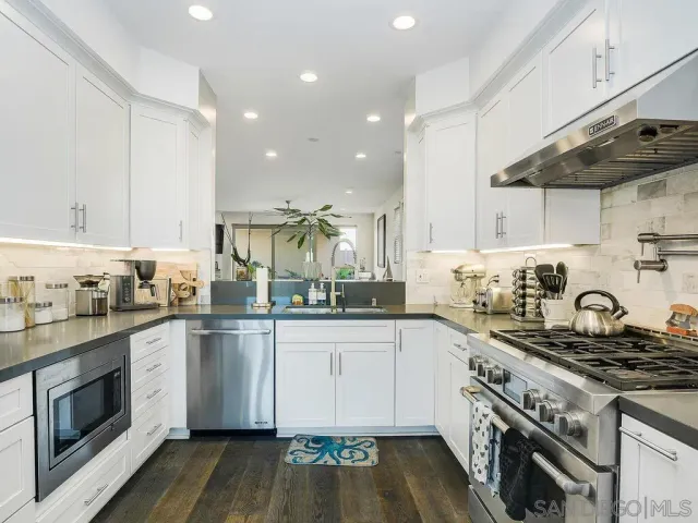 a kitchen with stainless steel appliances granite countertop a sink and a stove