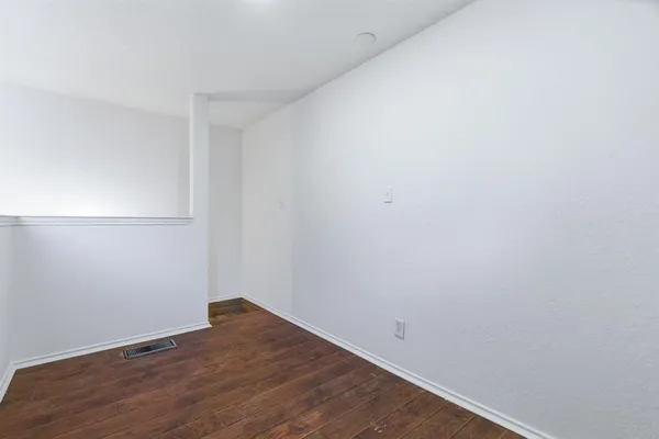 a view of small space with wooden floor and fan