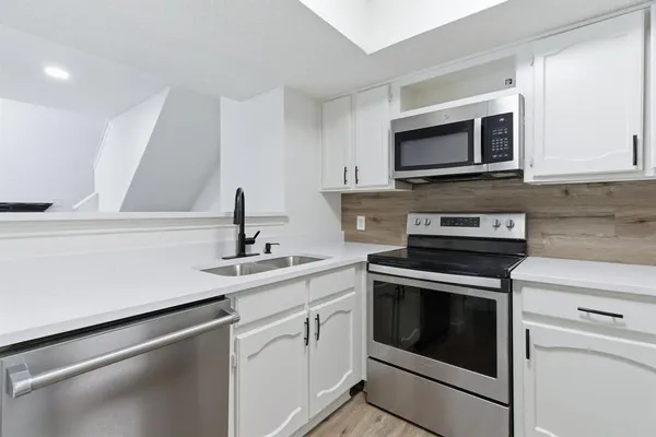 a kitchen with stainless steel appliances granite countertop a sink stove and microwave