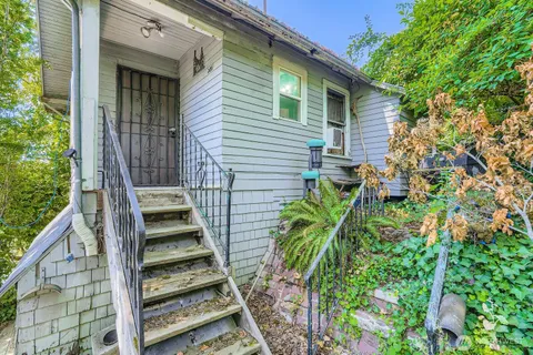 a view of a house with backyard and wooden fence