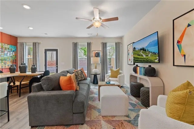 a living room with furniture a large window and a flat screen tv