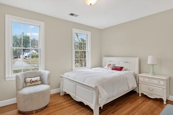 a bedroom with a bed and wooden floor