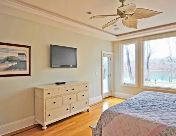 a bedroom with a bed dresser and wooden floor