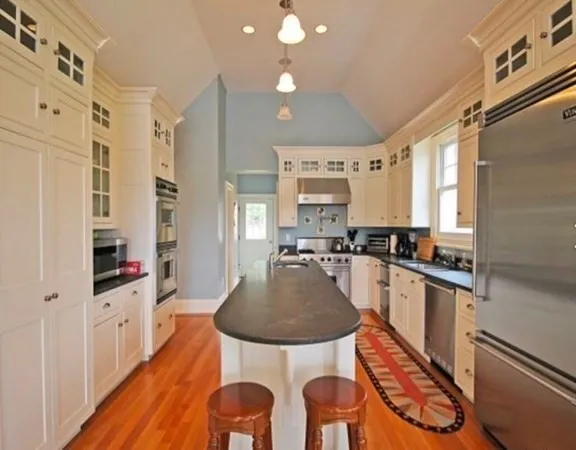 a kitchen with stainless steel appliances a stove a table and chairs