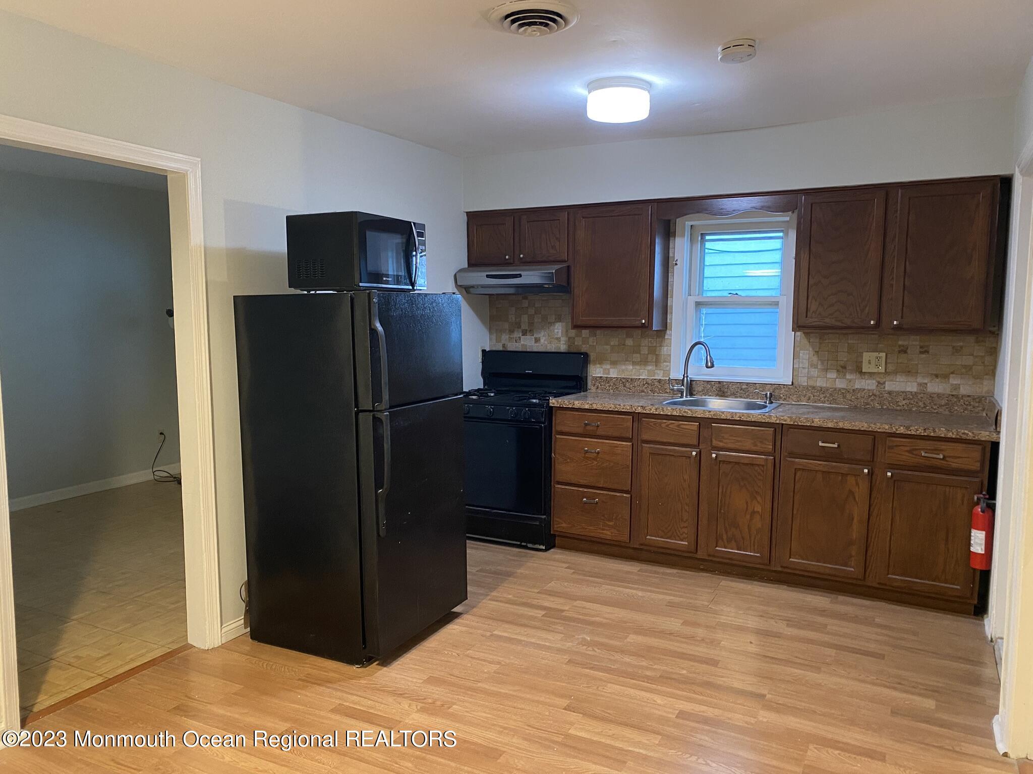 511 Bay Avenue, Unit 2 Point Pleasant Beach, NJ 08742 - Photo 2 of 13 a kitchen with stainless steel appliances granite countertop a refrigerator and a sink