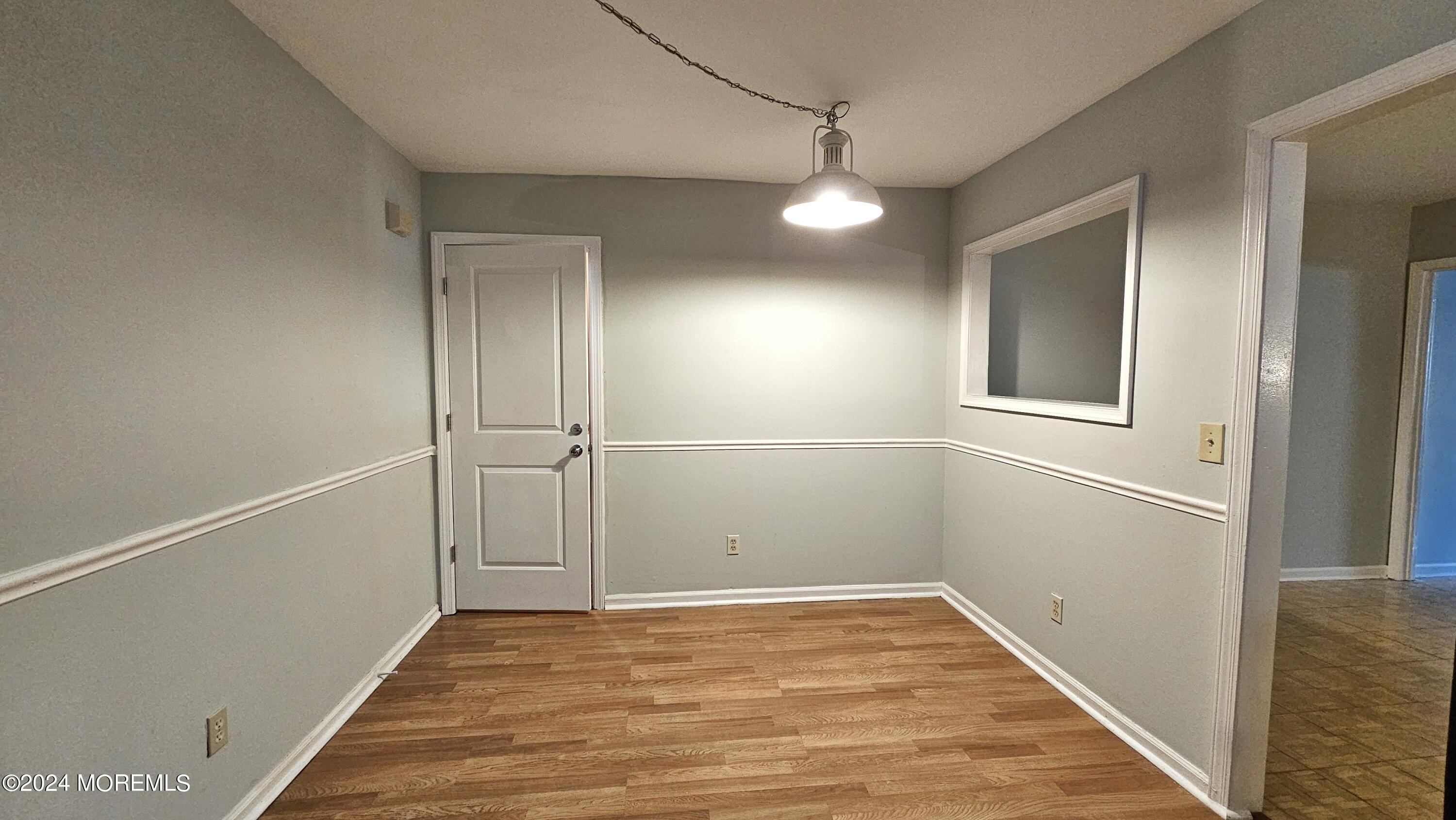 511 Bay Avenue, Unit 2 Point Pleasant Beach, NJ 08742 - Photo 3 of 13 a view of an empty room with wooden floor and a bathroom