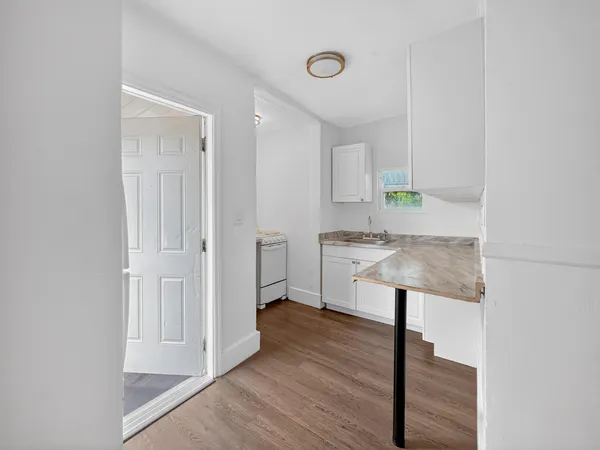 a kitchen with stainless steel appliances a sink cabinets and wooden floor