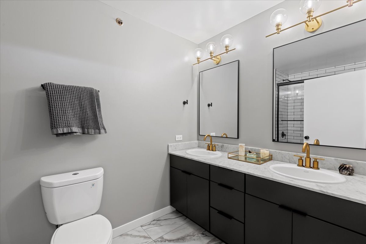 1224 West Van Buren Street, Unit 304 Chicago, IL 60607 - Photo 13 of 29 a bathroom with a toilet sink and mirror