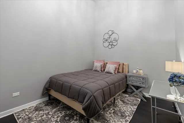 a bedroom with a bed and a lamp on dresser