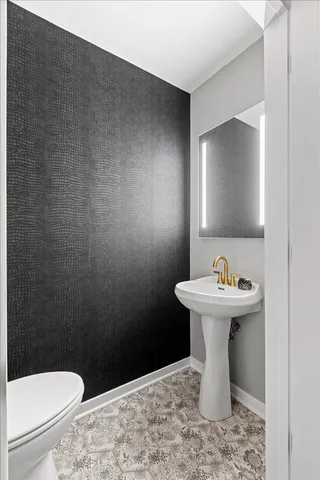 a bathroom with a sink a toilet and a mirror