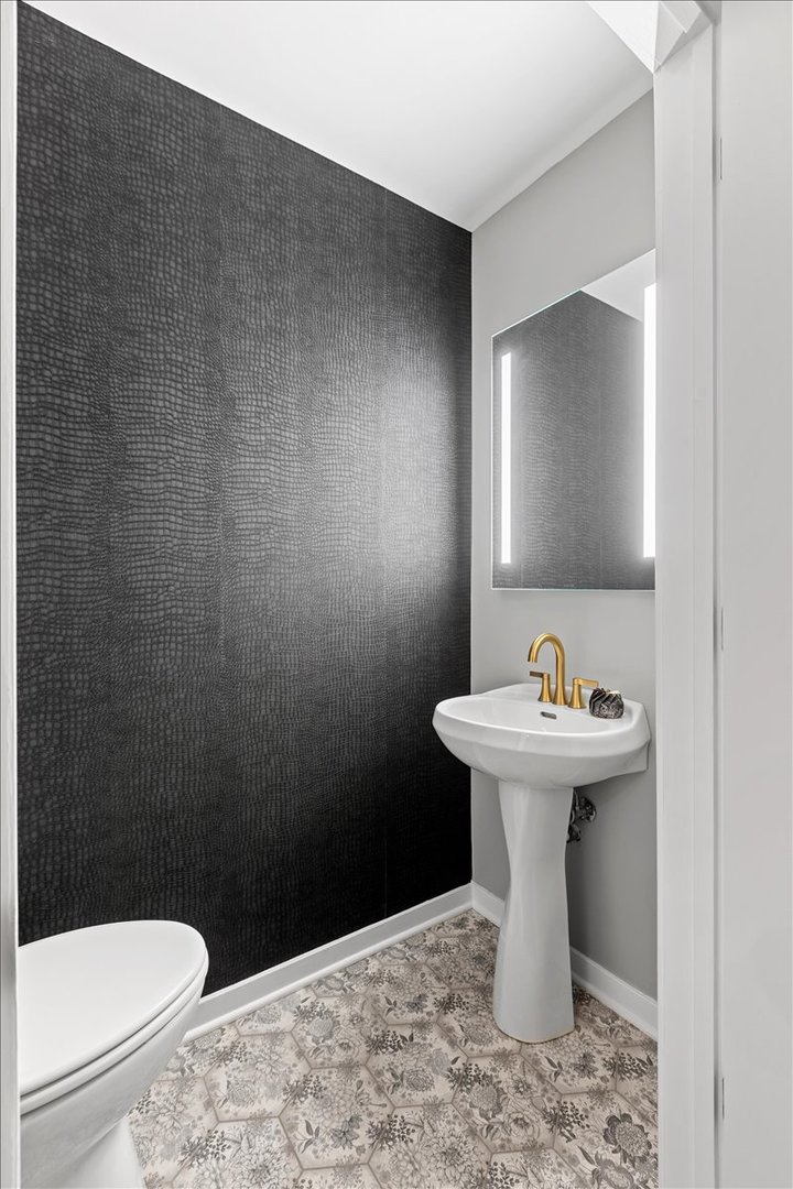 1224 West Van Buren Street, Unit 304 Chicago, IL 60607 - Photo 16 of 29 a bathroom with a sink a toilet and a mirror