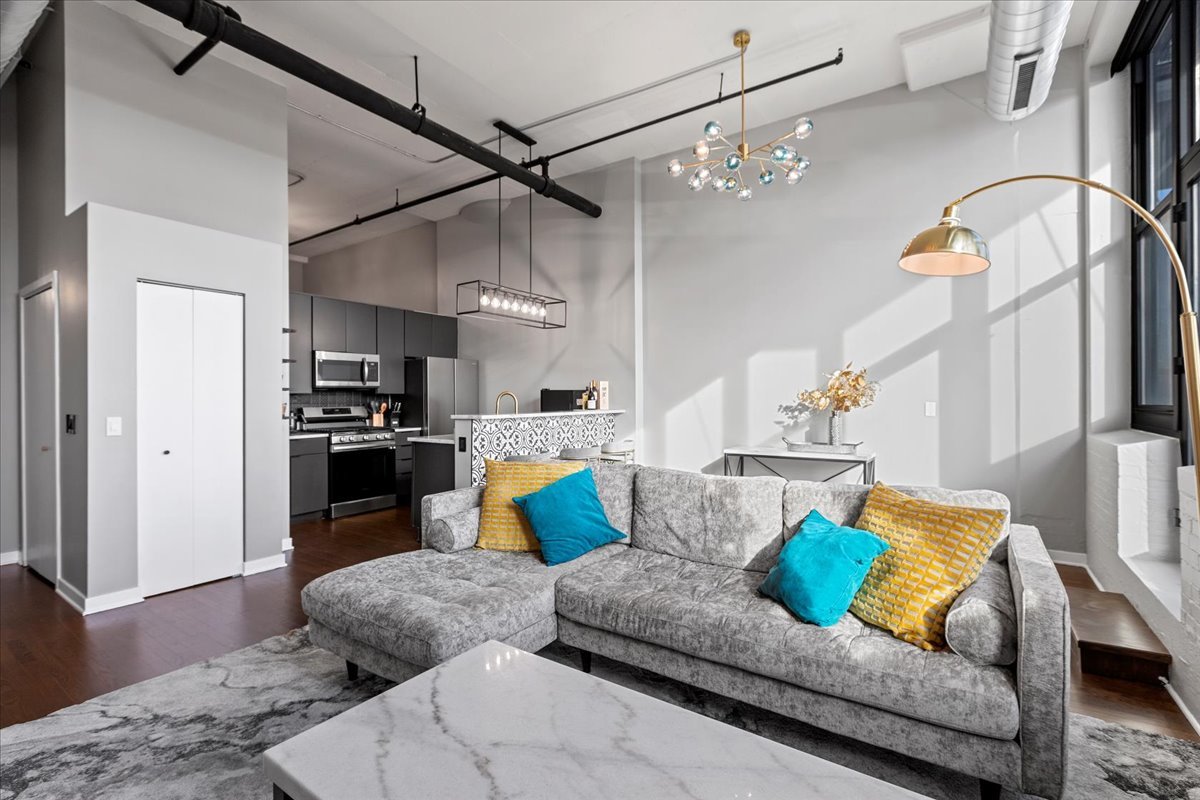 1224 West Van Buren Street, Unit 304 Chicago, IL 60607 - Photo 3 of 29 a living room with furniture kitchen view and a chandelier