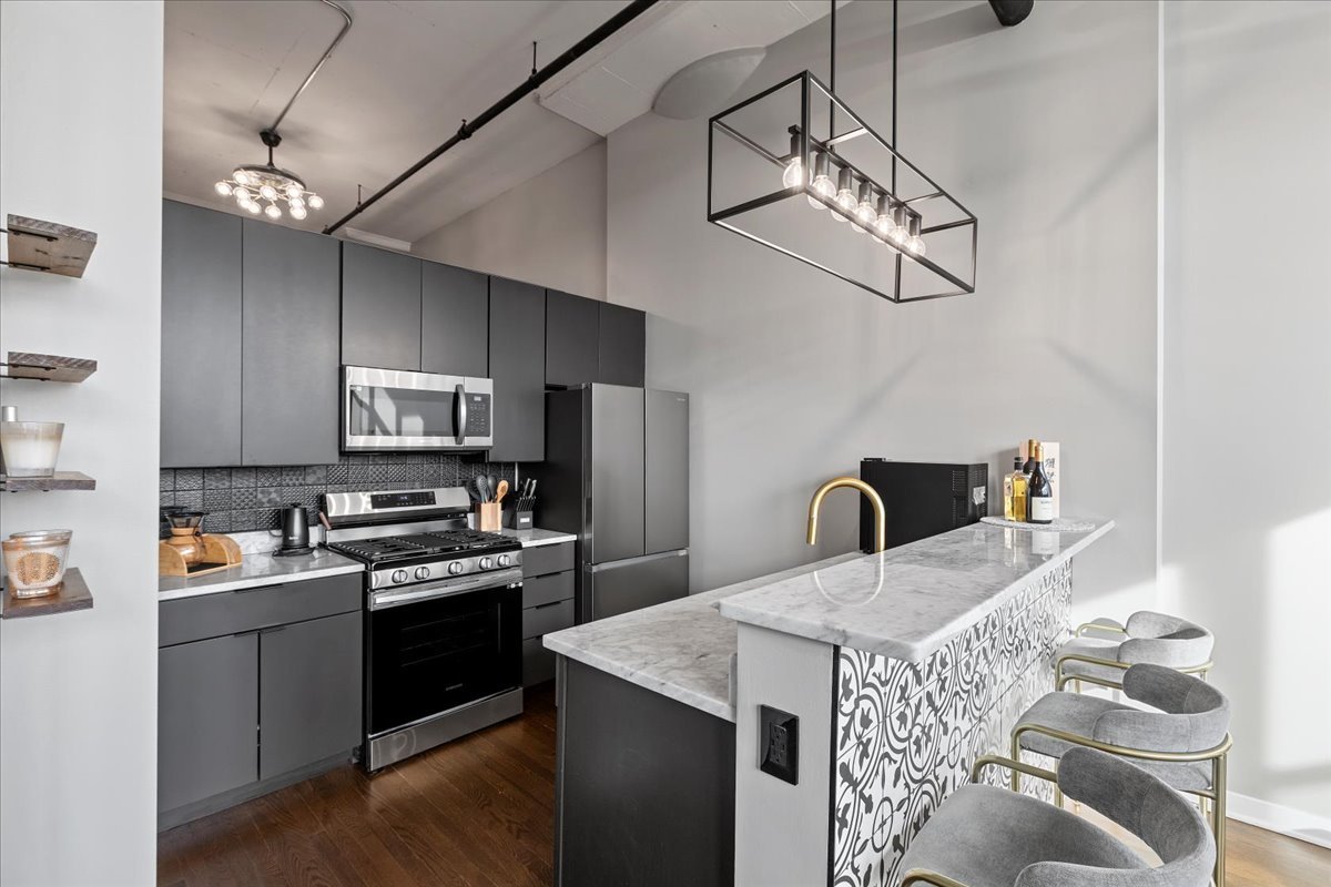 1224 West Van Buren Street, Unit 304 Chicago, IL 60607 - Photo 7 of 29 a kitchen with stainless steel appliances granite countertop a sink a stove a refrigerator cabinets a dining table and chairs