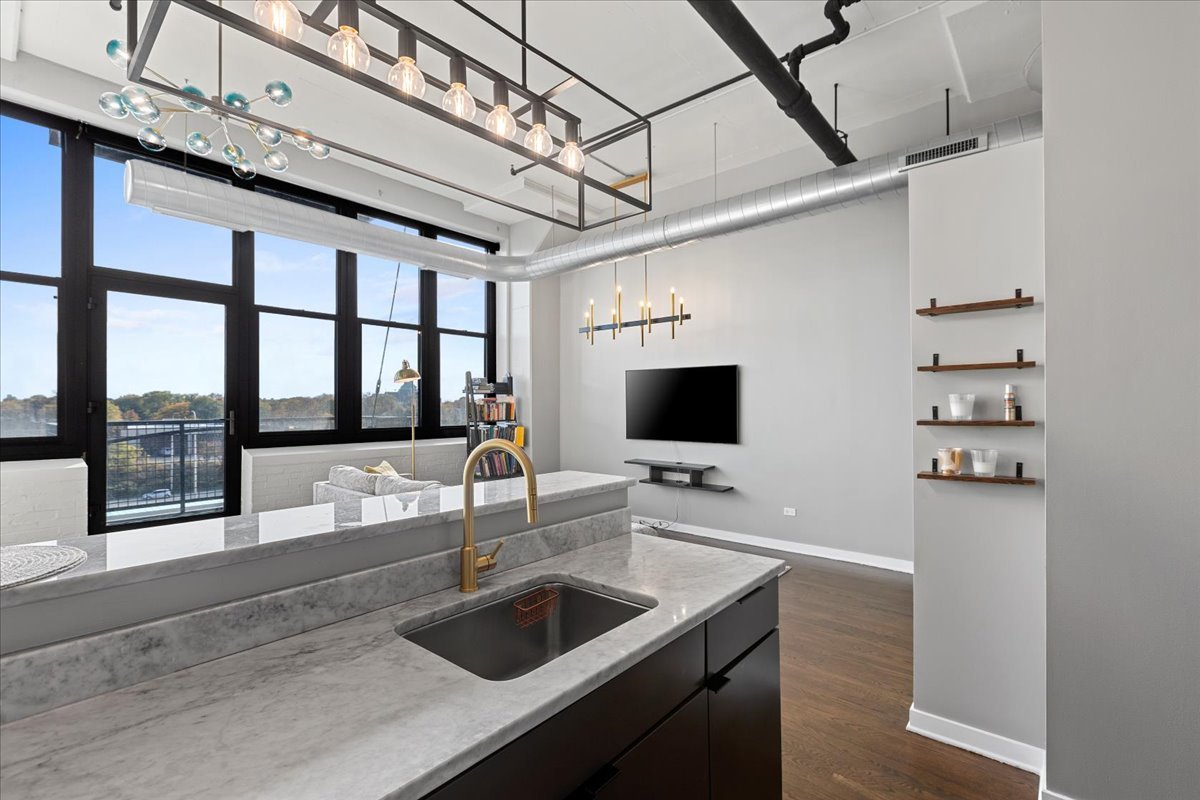 1224 West Van Buren Street, Unit 304 Chicago, IL 60607 - Photo 10 of 29 a kitchen with a sink a counter and a flat screen tv