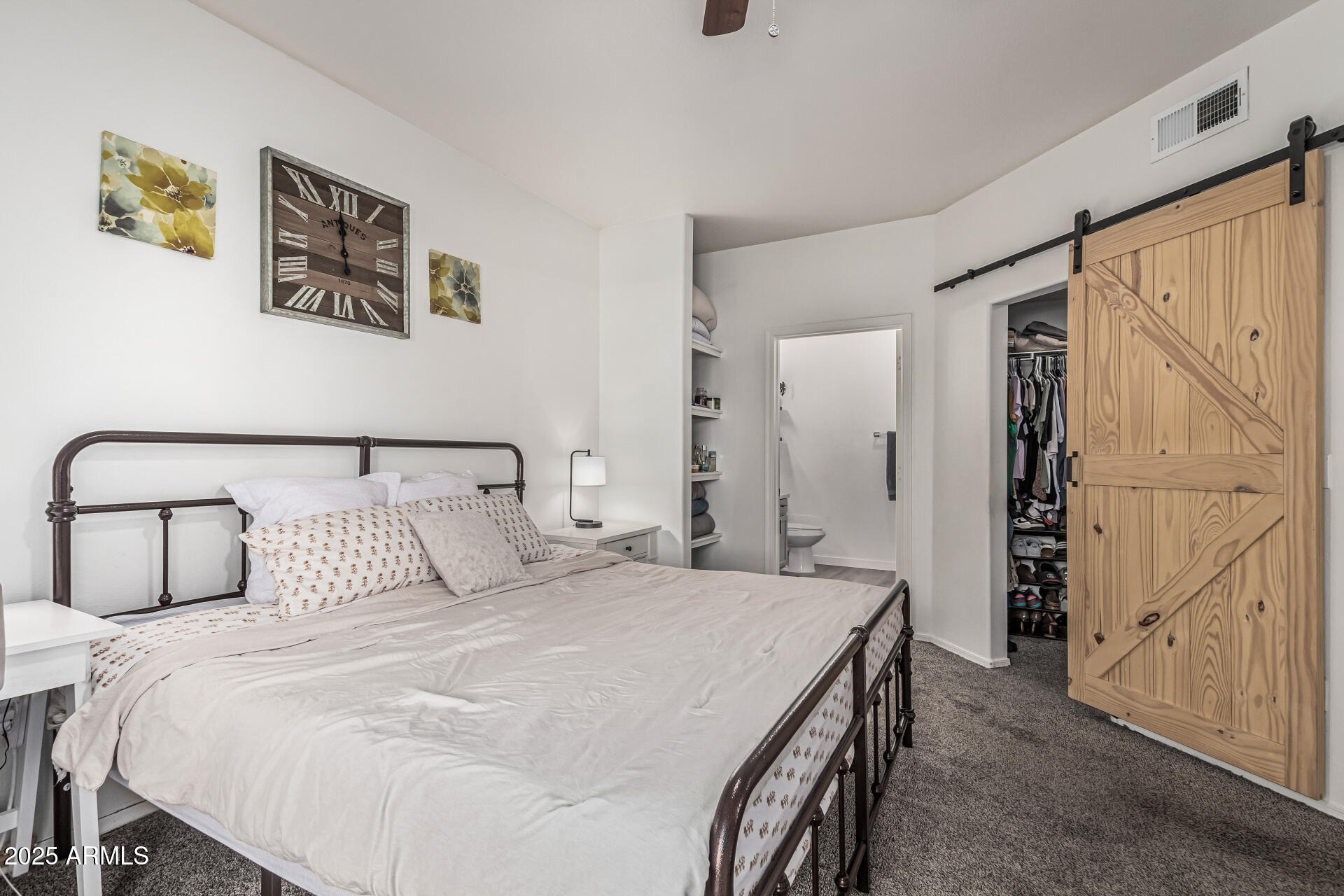 10030 West Indian School Road, Unit 255 Phoenix, AZ 85037 - Photo 13 of 26 a bedroom with a large bed and a chandelier