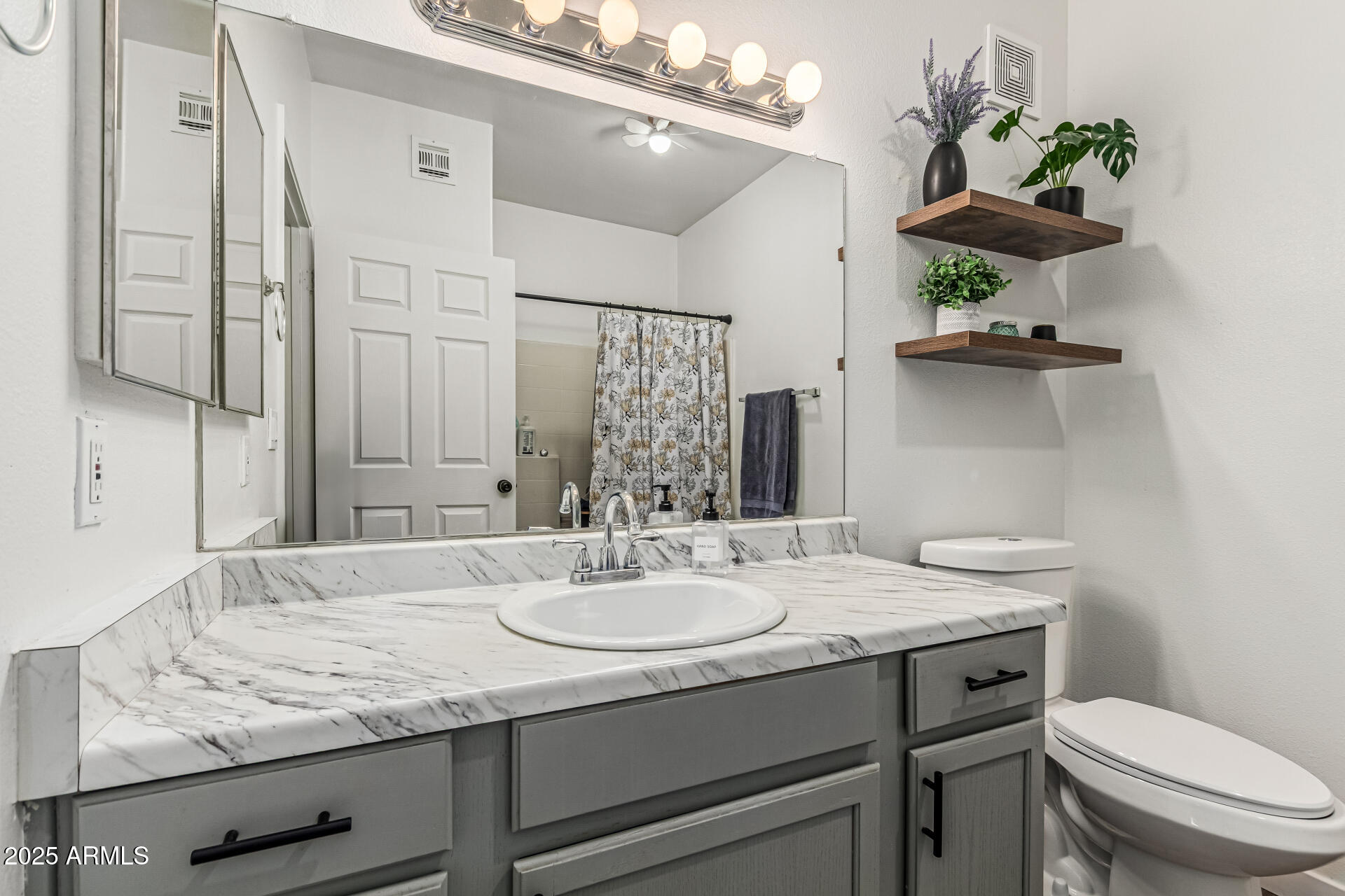 10030 West Indian School Road, Unit 255 Phoenix, AZ 85037 - Photo 14 of 26 a bathroom with a granite countertop sink a toilet and a mirror