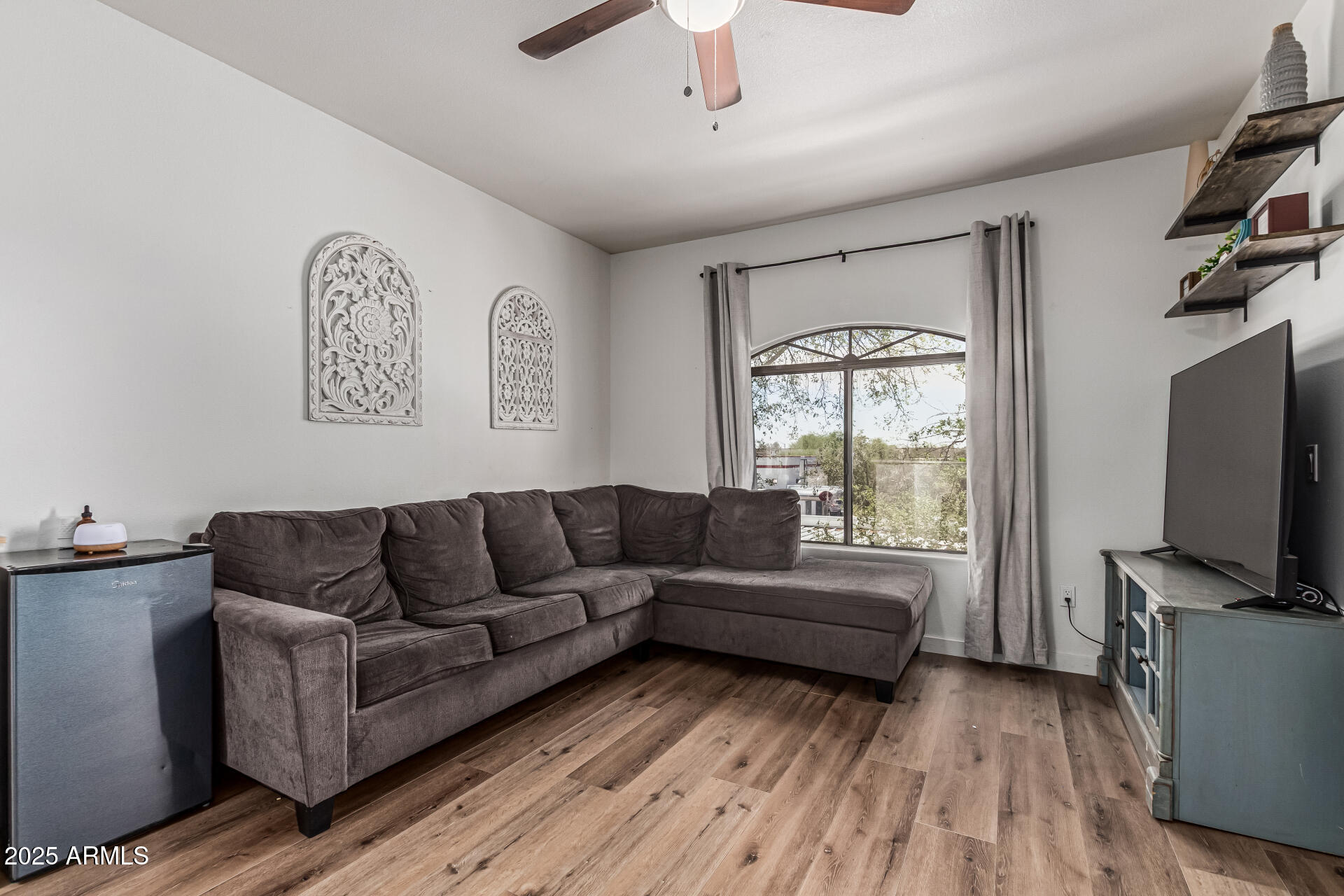 10030 West Indian School Road, Unit 255 Phoenix, AZ 85037 - Photo 4 of 26 a living room with furniture and a flat screen tv