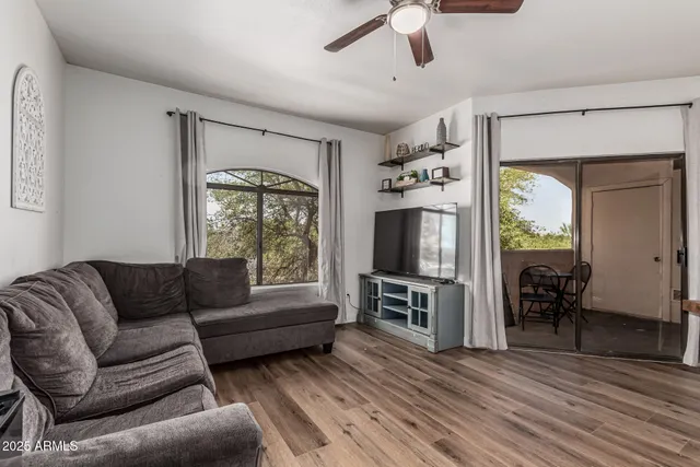 a living room with furniture a flat screen tv and a fireplace