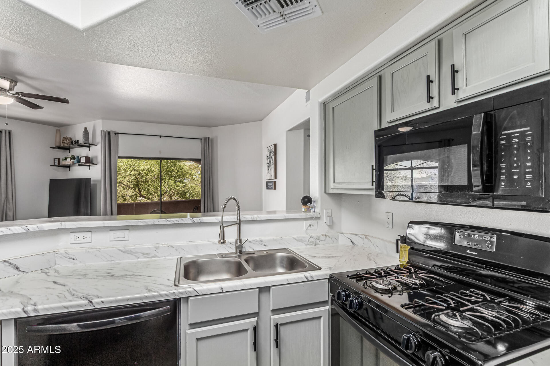10030 West Indian School Road, Unit 255 Phoenix, AZ 85037 - Photo 10 of 26 a kitchen with a sink stove top oven and cabinets