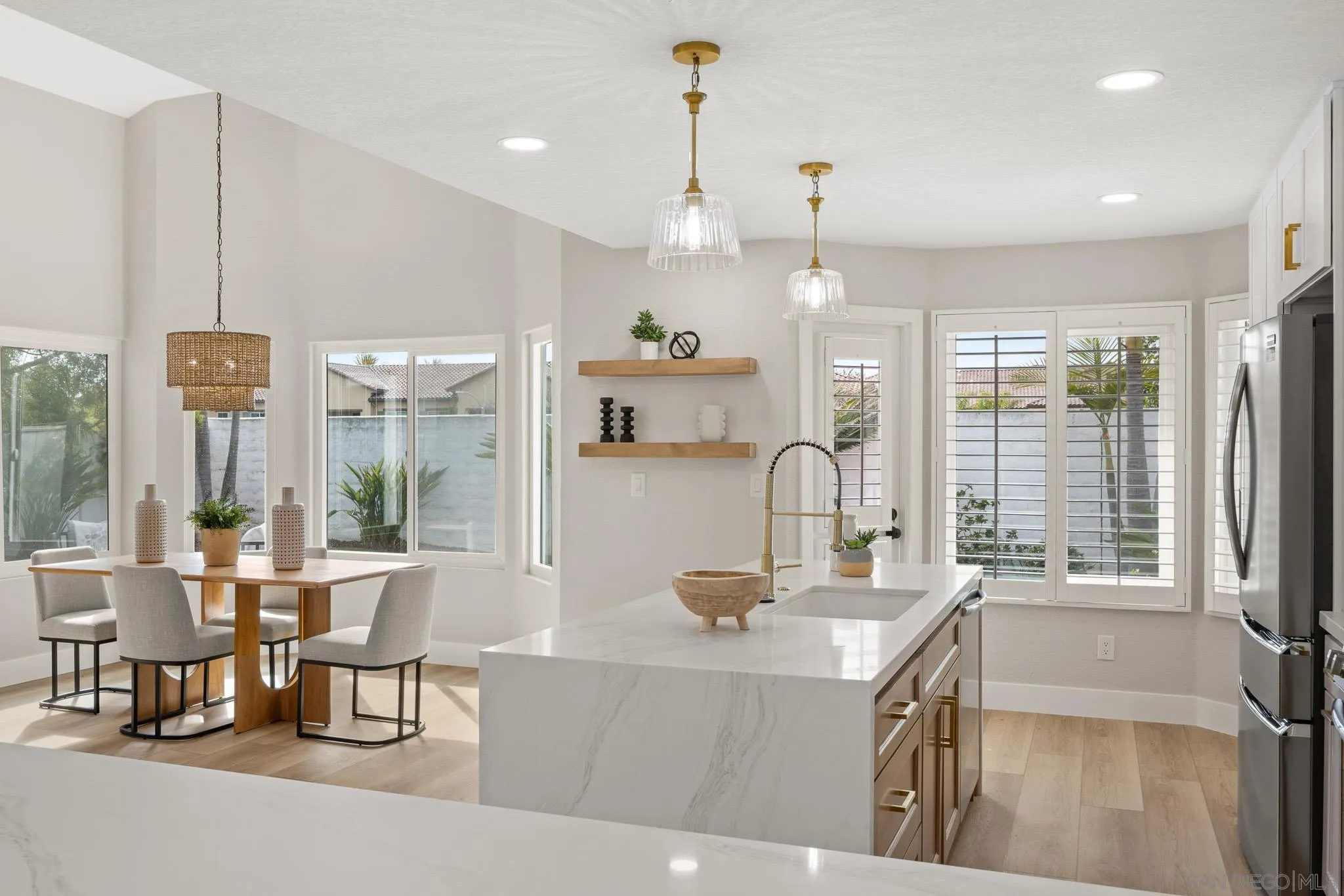 4661 Majorca Way Oceanside, CA 92056 - Photo 12 of 64 a room with stainless steel appliances kitchen island granite countertop a table chairs and a view of living room