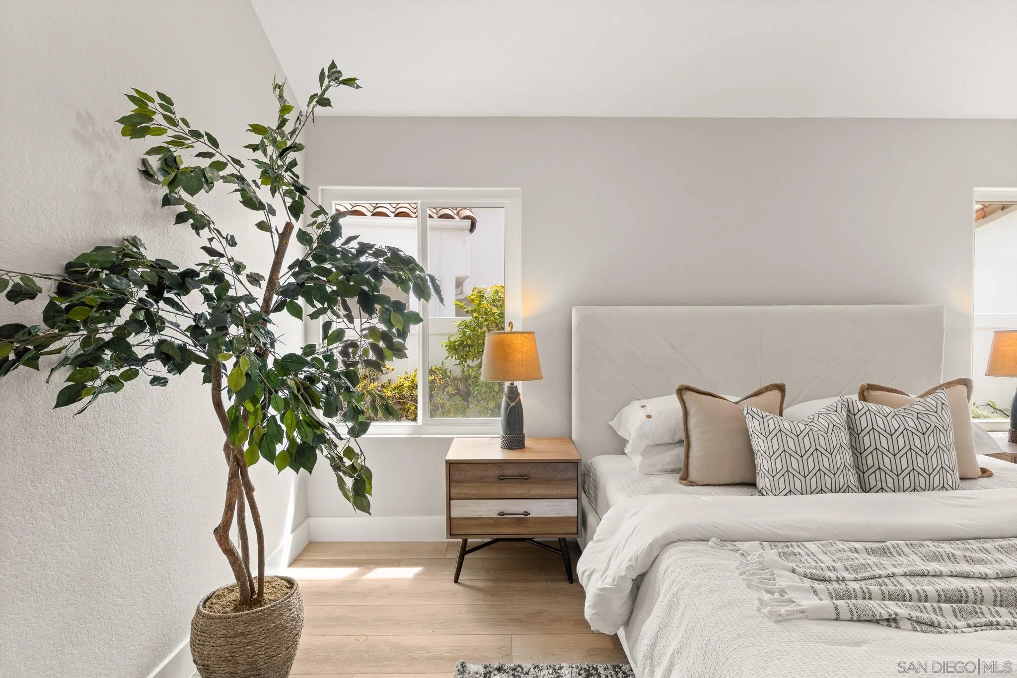 4661 Majorca Way Oceanside, CA 92056 - Photo 34 of 64 a bedroom with a bed and a potted plant