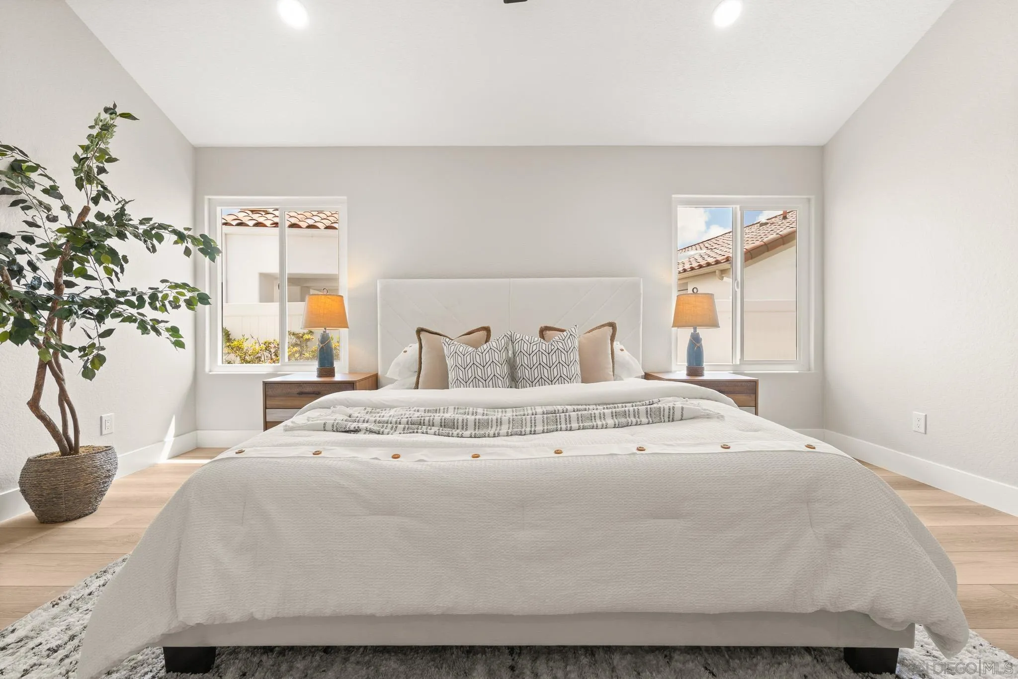 4661 Majorca Way Oceanside, CA 92056 - Photo 35 of 64 a bedroom with a bed and a potted plant