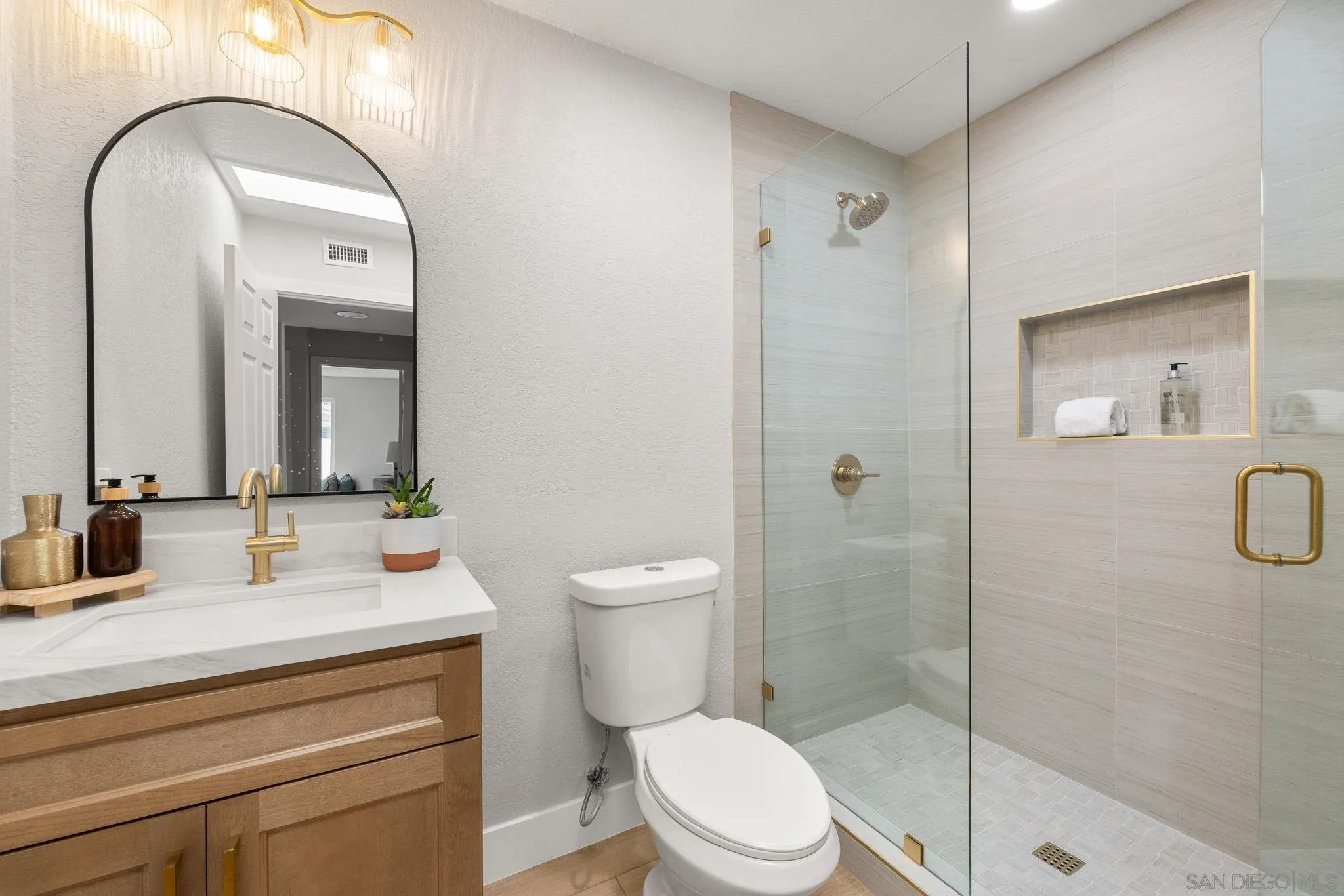 4661 Majorca Way Oceanside, CA 92056 - Photo 53 of 64 a bathroom with a toilet a sink a glass door a shower a mirror and vanity