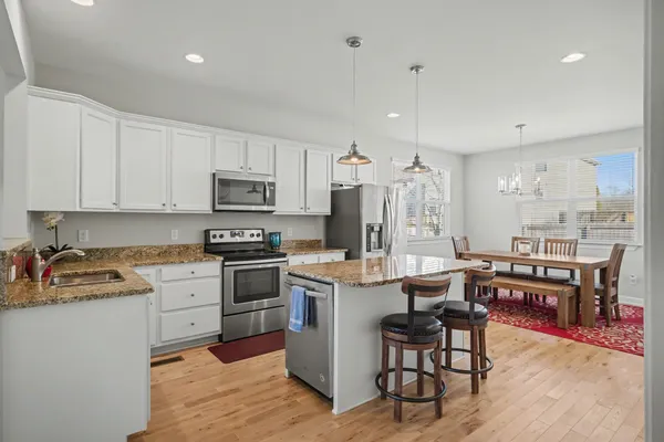 a kitchen with kitchen island granite countertop wooden cabinets and stainless steel appliances