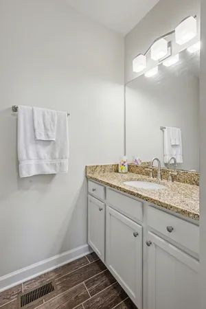 a bathroom with a granite countertop sink and a mirror