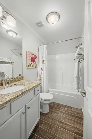 a bathroom with a granite countertop sink toilet and shower