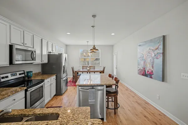 a kitchen with stainless steel appliances a stove refrigerator sink and microwave