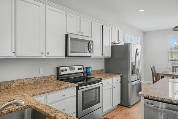 a kitchen with stainless steel appliances granite countertop a refrigerator sink and stove