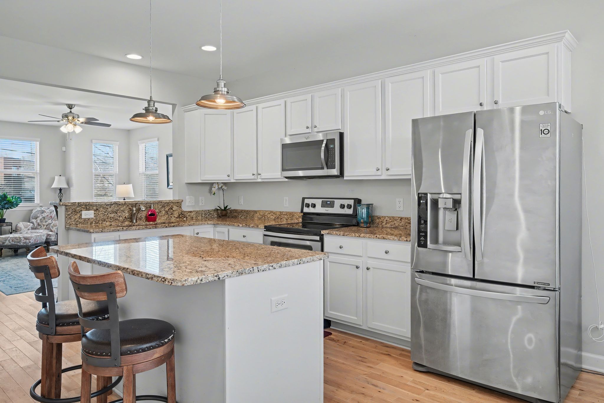 912 Pierce Road Madison, TN 37115 - Photo 10 of 32 a kitchen with granite countertop a refrigerator a stove a sink dishwasher and white cabinets with wooden floor