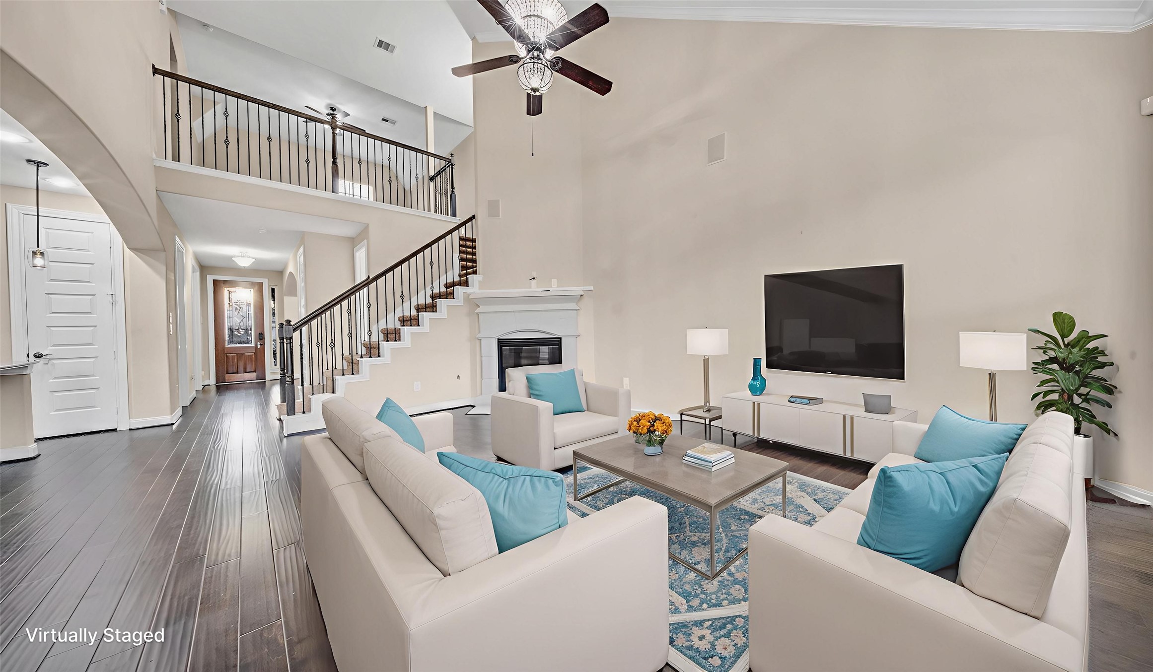 18118 Berry Garden Lane Spring, TX 77379 - Photo 10 of 45 Expansive two-story living area featuring elegant iron stair railings and open sightlines to the foyer and kitchen, virtually staged for scale and flow.