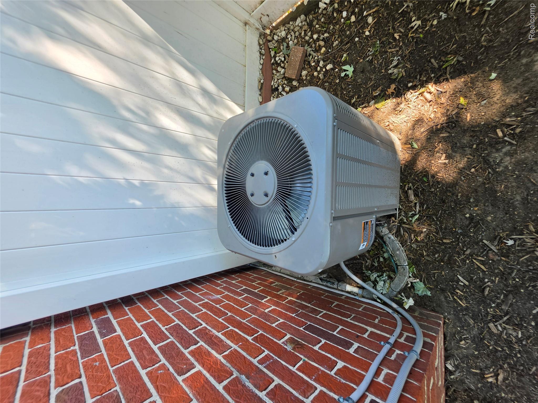 31159 Kelly Road Fraser, MI 48026 - Photo 28 of 34 Efficient HVAC unit positioned in side yard with brick exterior and metal fencing visible