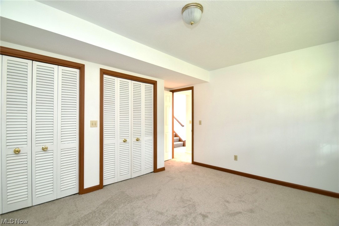 9699 Mulberry Road Chardon, OH 44024 - Photo 14 of 24 Lower level bedroom featuring light carpet and two closets