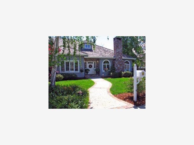 a view of a house with a yard and potted plants